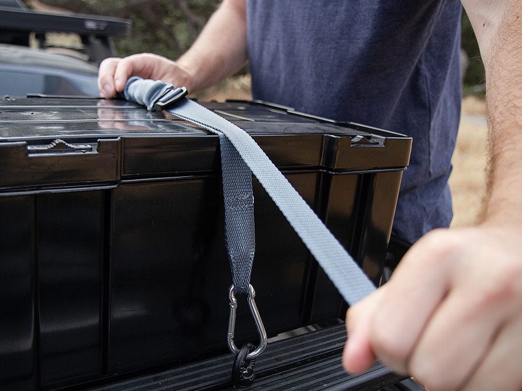 Front Runner Stratchit Shorties strap being hand-tightened over a storage box on a roof rack